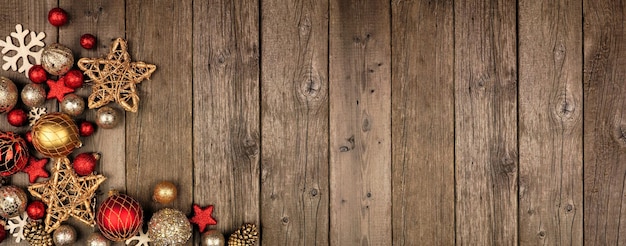 Photo red and gold christmas ornament corner border banner above view on a rustic wood background