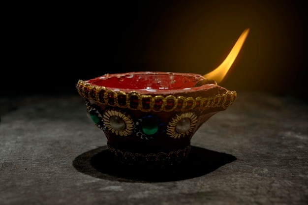 Photo a red and gold decorated pot with a blue and white design sits on a dark surface