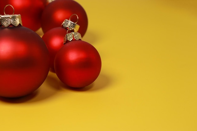 red and golden Christmas ornament balls on yellow background. Flat lay, top view, copy space