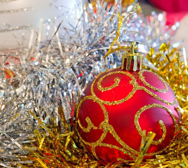 Red golden and silver Christmas ball surrounded by decorations