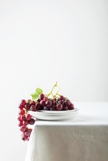 Red grape on the white linen tablecloth