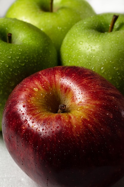 Red and green apples with water drops