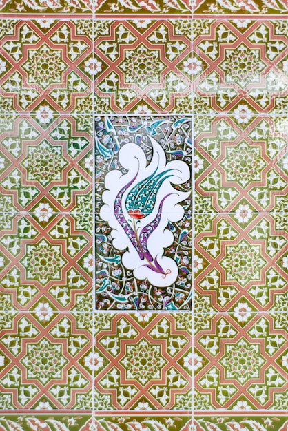 Red green and white ceramic tile with geometric pattern and beautiful flower in the center