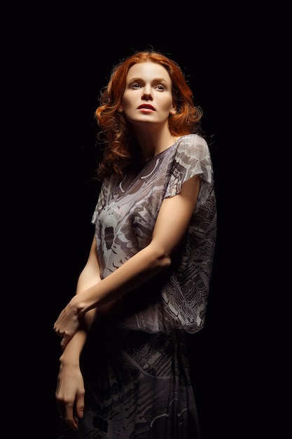 Red hair model posing in fashion dress