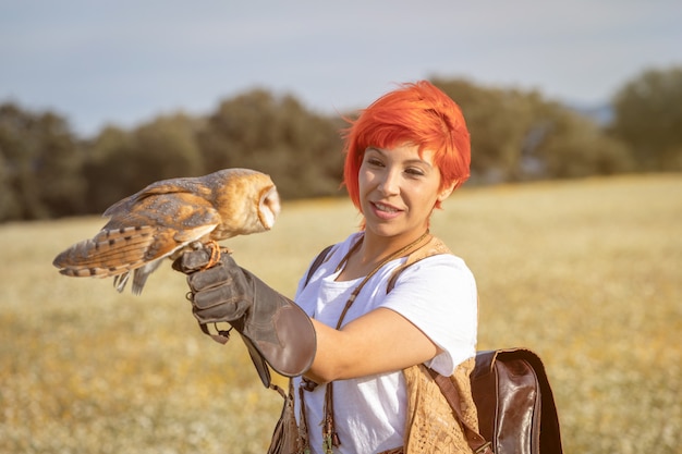 Photo red hair woman with a white owl on her arm