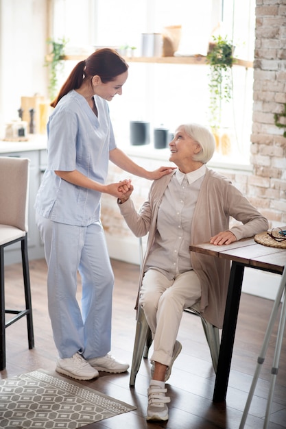 Red-haired caregiver in uniform speaking with patient