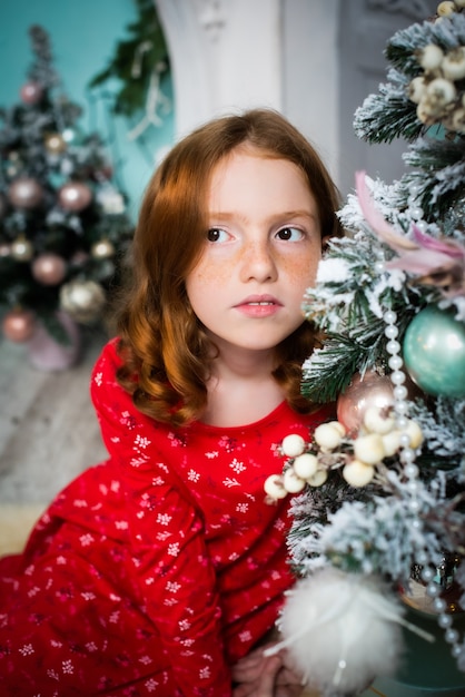 Red-haired girl dreams of near the Christmas tree.