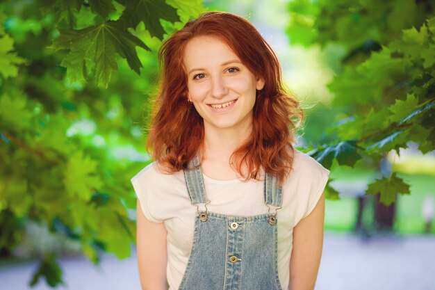 Red-haired girl posing in the park