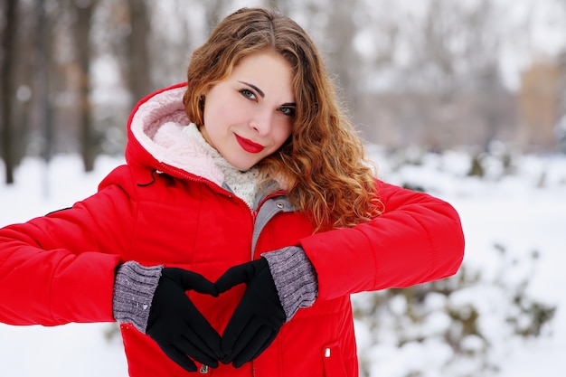 Red-haired girl showing a heart with her hands on valentine's day