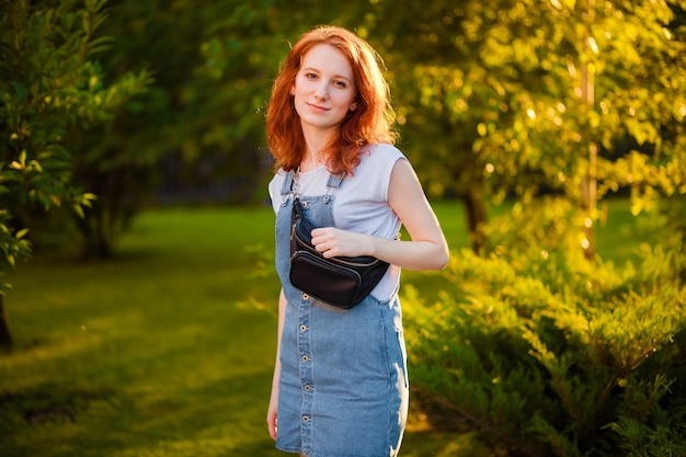 Red-haired girl with waist bag in the Park