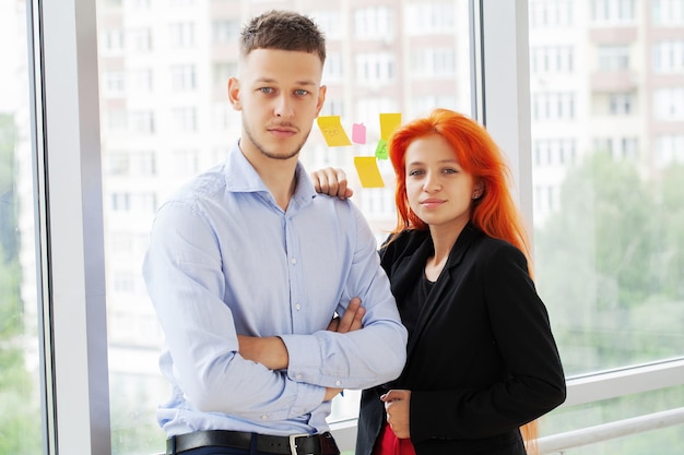 A red haired girl works together with a partner in the office on a joint project