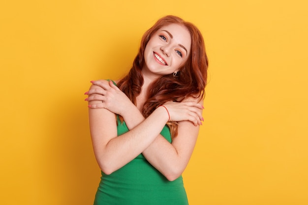 Red haired young beautiful woman looks smiling