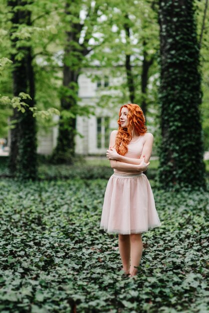 Red-haired young woman walking in a park