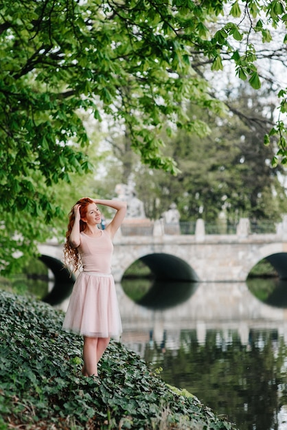 Red-haired young woman walking in a park