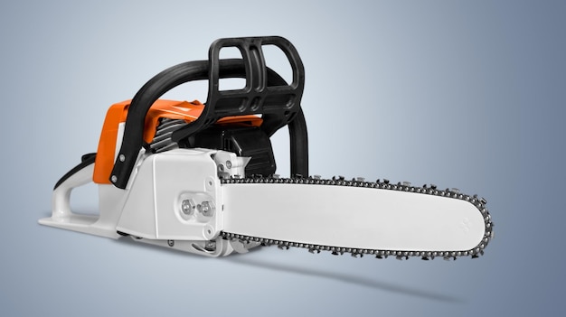 Red hand electric chainsaw on gray background