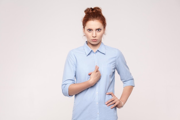 Red head lady boss looking at camera with seriously face and pointong finger to myself