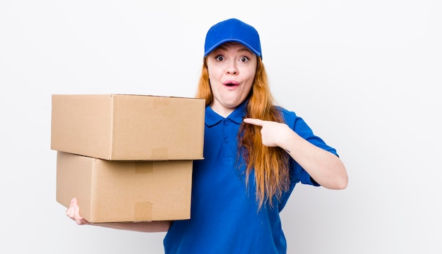 Red head pretty woman feeling happy and pointing to self with an excited shipping boxes concept