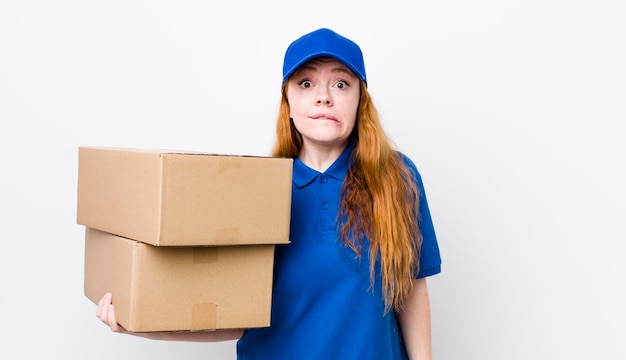 Red head pretty woman looking puzzled and confused shipping boxes concept