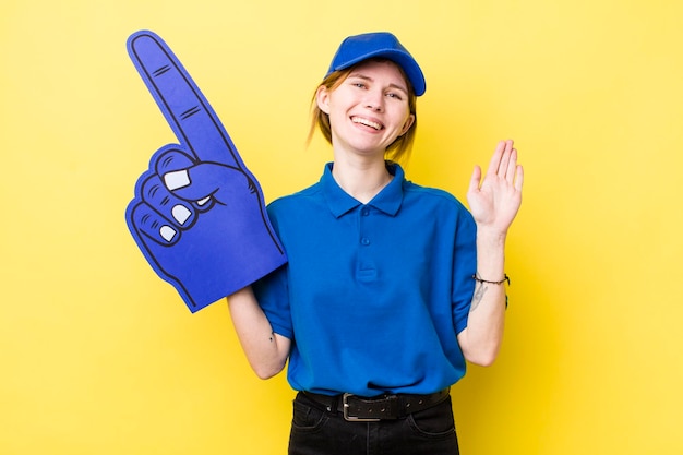 Red head pretty woman smiling happily waving hand welcoming and greeting you number one hand fan concept