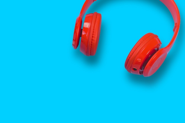 Red headphones on blue pastel table