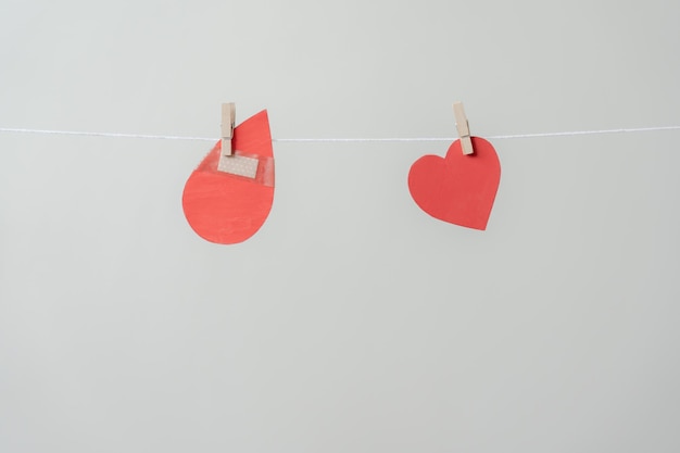 Red heart and blood drop paper sign hanging on rope