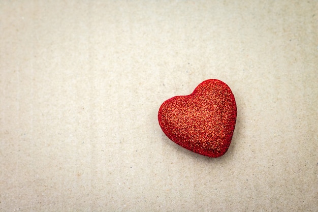 Red heart on cardboard background. Valentine wallpaper.