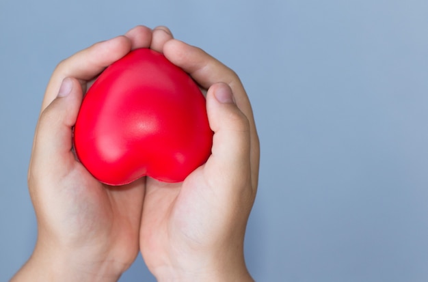 Photo red heart in child kid hands on blue background