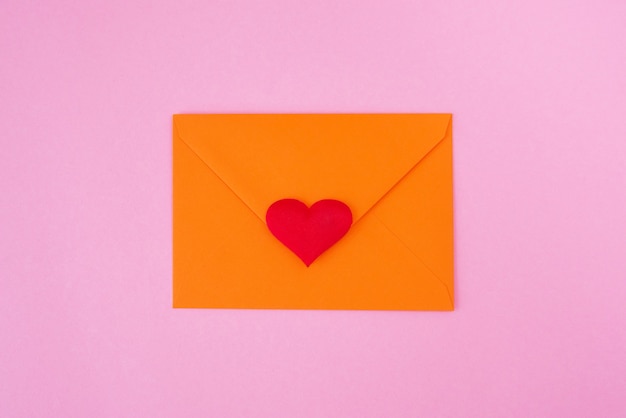 Red heart and envelope on pink background