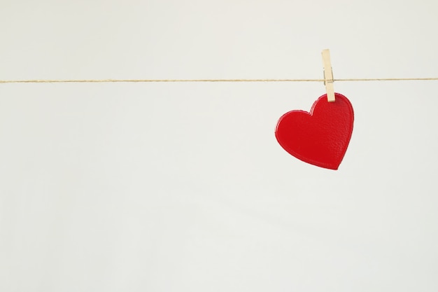 Red heart hanging on a clothesline for valentine's day.                               