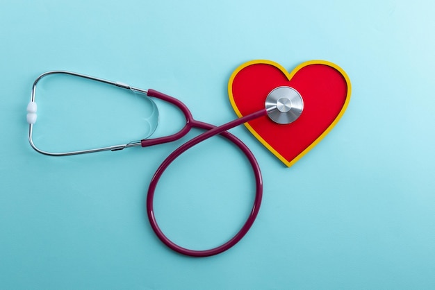 Red heart and stethoscope lies on a blue background