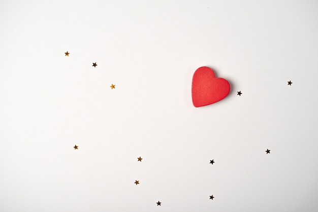 Red heart on the white background with golden stars. Valentine's Day concept.