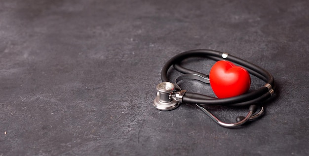 Red heart with stethoscope on dark background heart health health insurance concept World heart day