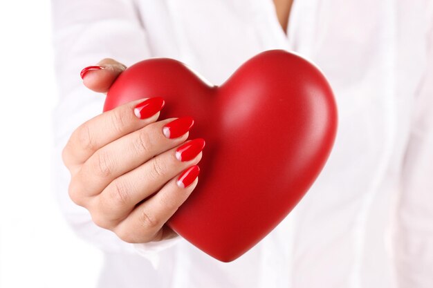 Red heart in woman's hand isolated on white