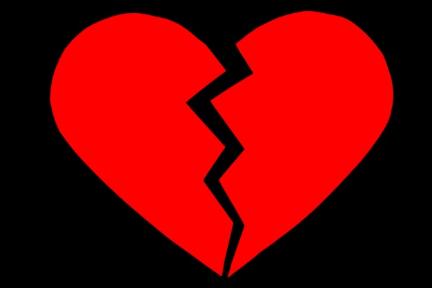 Photo red heartbreak / broken heart. close up of a paper broken heart on black background with clipping path