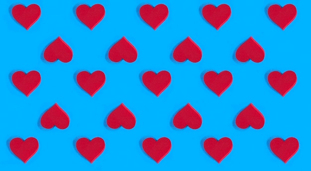 Red hearts on the blue background Pattern Flat lay