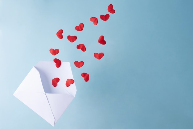 Red hearts fly out of a white envelope, Valentine's Day.