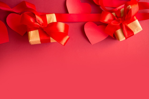 Red hearts and gifts on a box in a red background. Valentine's Day Gift