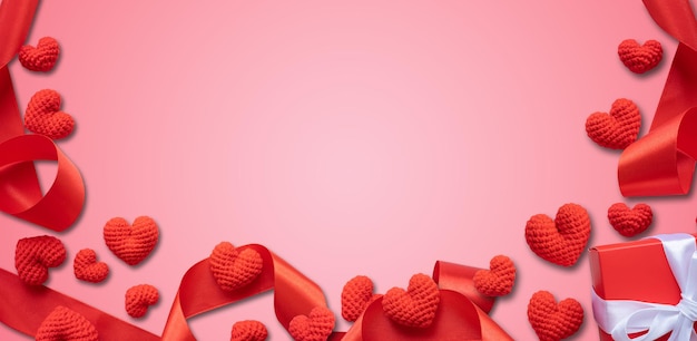 Red hearts and ribbons on pastel pink background Valentines Day