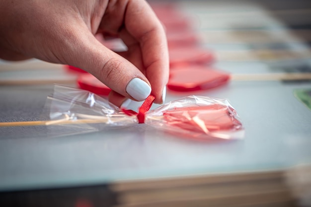 Red heartshaped lollipop in female hands close up