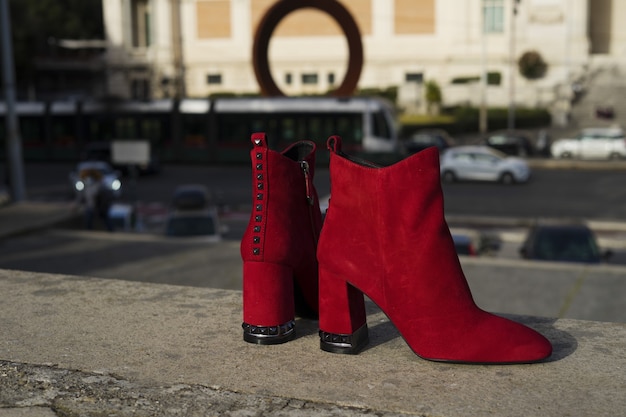 Red high heel boot with city background