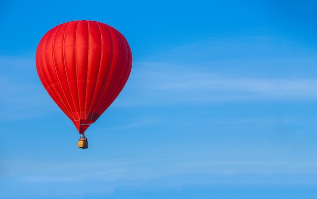 Red hot air balloon in blue sky. Travel background