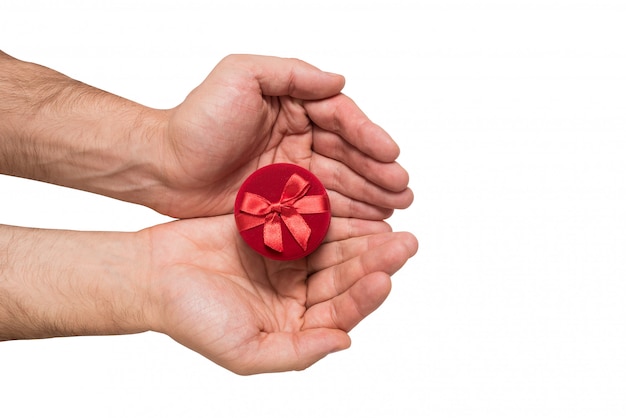 Red jewelry box in man hands. Present. White background. Top view