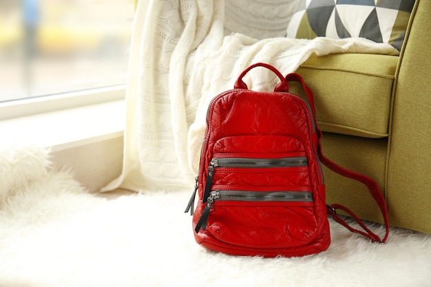 Red leather backpack on the floor