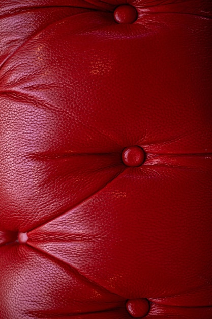 The red leather upholstery of sofa padding with buttonsTexture