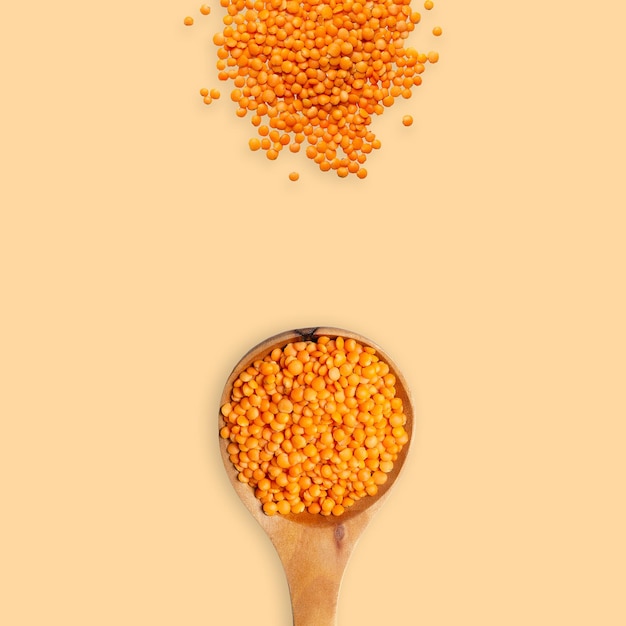 Red lentils isolated on orange background with copy space