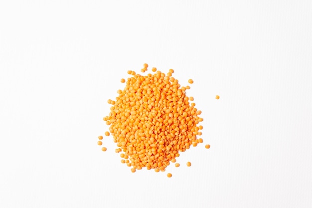 Red lentils sprinkled on white background