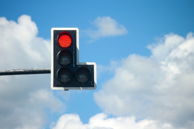 Red light traffic lights against blue sky.