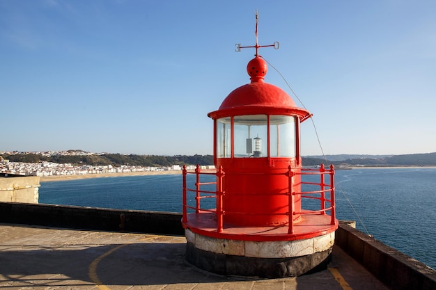 Red lighthouse lamp room on blue sky and sea background