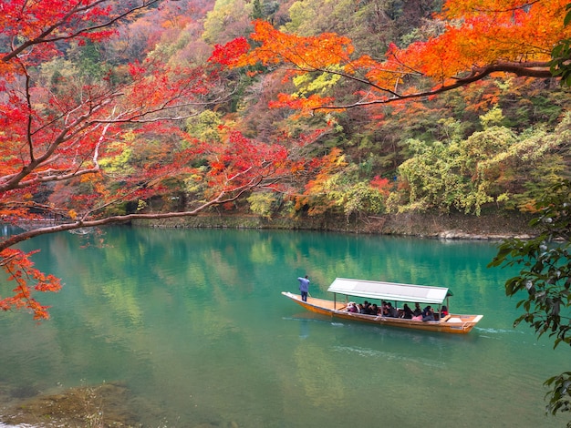 Red maple leaf and Katsura river at Arashiyama, Kyoto.