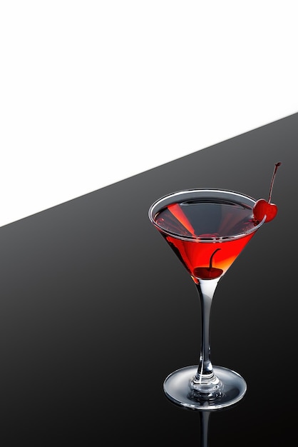 Red martini cocktail on a dark background with a red cherry